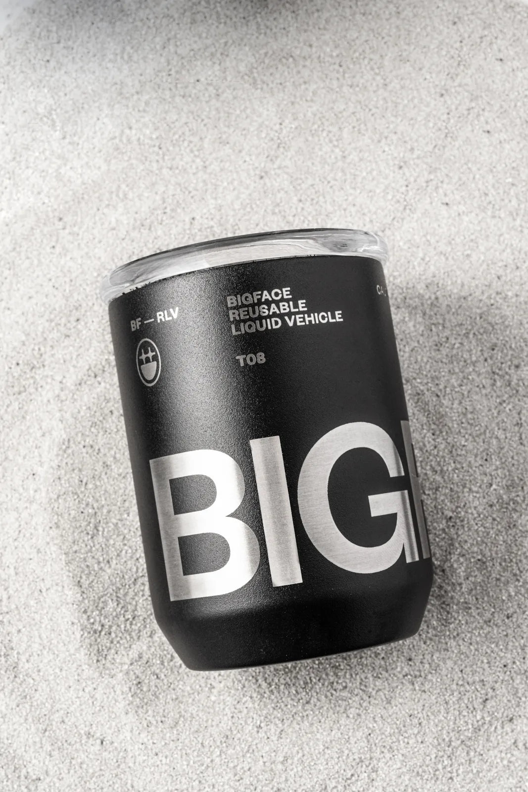 BIGFACE reusable tumbler resting in sand